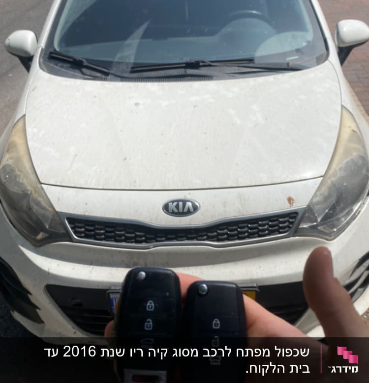 שני מפתחות רכב, אחד חדש ואחד ישן, מול רכב קיה
